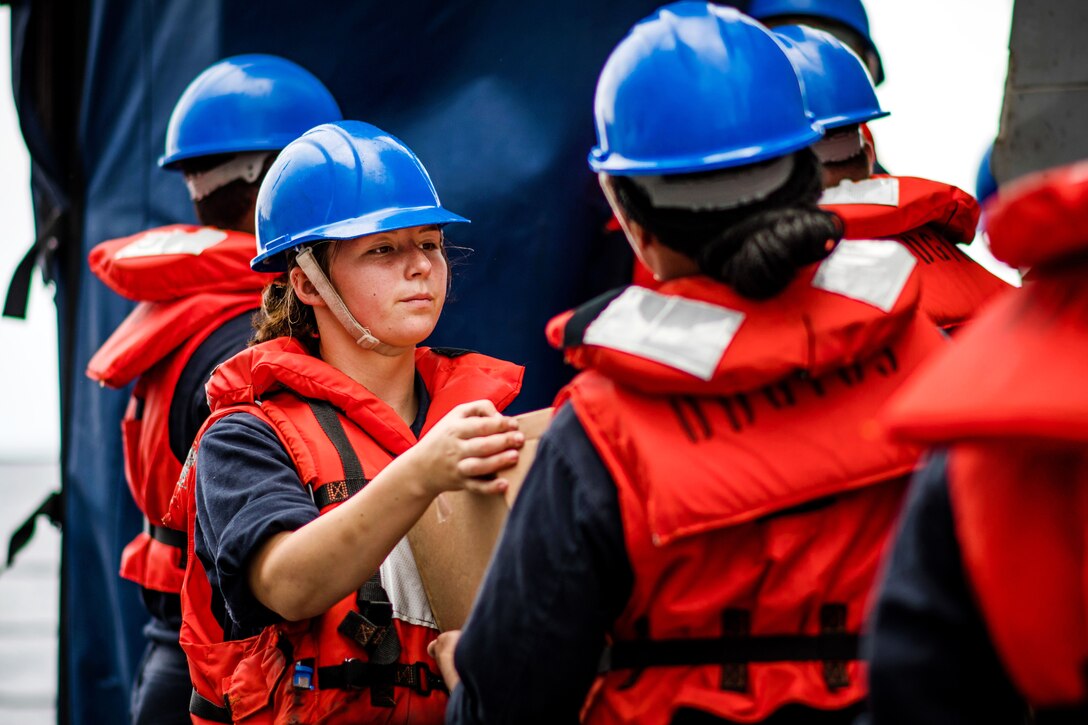 Sailors pass boxes of food and supplies during a replenishment-at-sea.