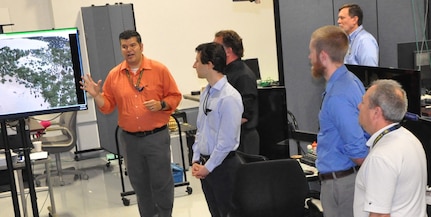 IMAGE: DAHLGREN, Va. (June 21, 2018) - Dr. David Keller from the NSWC Dahlgren Division Human Systems Integration Branch Science and Technology group demonstrates a prototype to evaluate the effectiveness of different controls, communication, feedback methods, and teaming between a manned and unmanned team for ground based operations. Keller briefed Propel students during their tour of NSWCDD that focused on the Electromagnetic Railgun Facility, the Potomac River Test Range, and the Human Performance Laboratory. The five-day Propel course provides an introductory level awareness of Warfare Center expectations for new supervisors.  (U.S. Navy photo/Released)