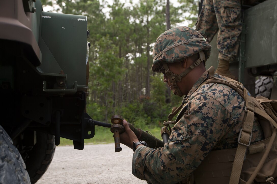 A U.S. Marine with II Marine Expeditionary Force Support Battalion, II MEF Information Group, prepares a notionally damaged Humvee to be towed during a battalion field exercise at Camp Lejeune, N.C., July 17, 2018. The training was conducted to improve the Marines’ ability to perform combat tactics in a combat environment and maintain unit readiness. (U.S. Marine Corps photo by Lance Cpl. Camila Melendez)