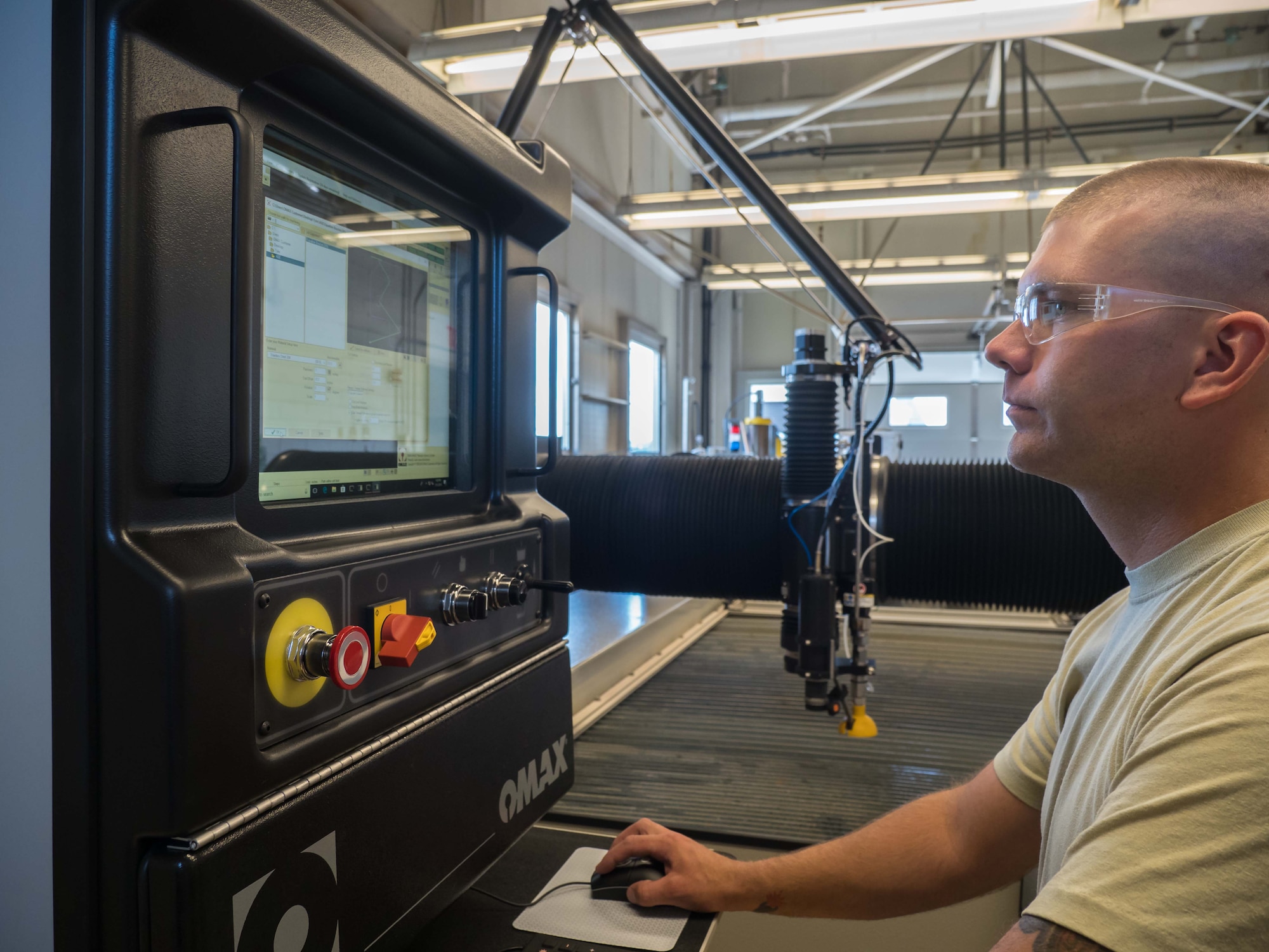Tech. Sgt. Tyler Horner operates the water jet cutting machine. (Air Force Photo/Paul Zadach)