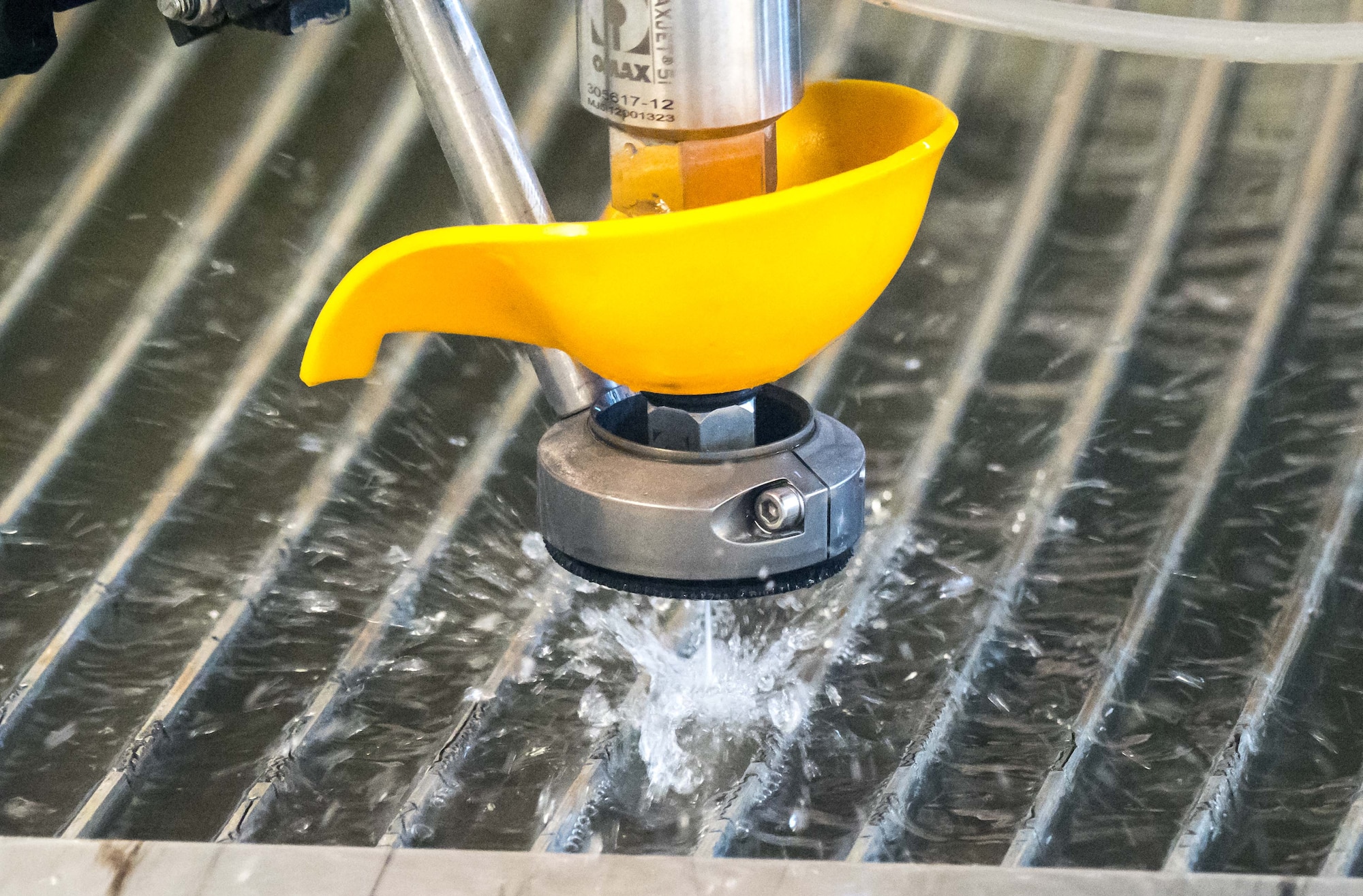 With the cutting nozzle out of the water, the water/garnet mix propelled at mach 2 at a force of 60,000 PSI can be observed. (Air Force Photo/Paul Zadach)