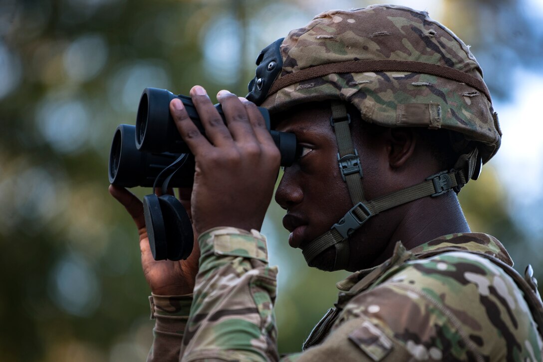 An Airman from the 822d Base Defense Squadron (BDS) scans the woods through his binoculars during a full mission profile assessment, July 24, 2018, at Moody Air Force Base, Ga. The ‘Safeside’ defenders evaluated their base defense tactics and procedures while performing patrols, tactical combat casualty care and countering improvised explosive devices for a mission readiness exercise. After successfully completing these events, the defenders are eligible to earn their Global Response Force status, which certifies the unit to deploy worldwide. (U.S. Air Force photo by Airman Taryn Butler)