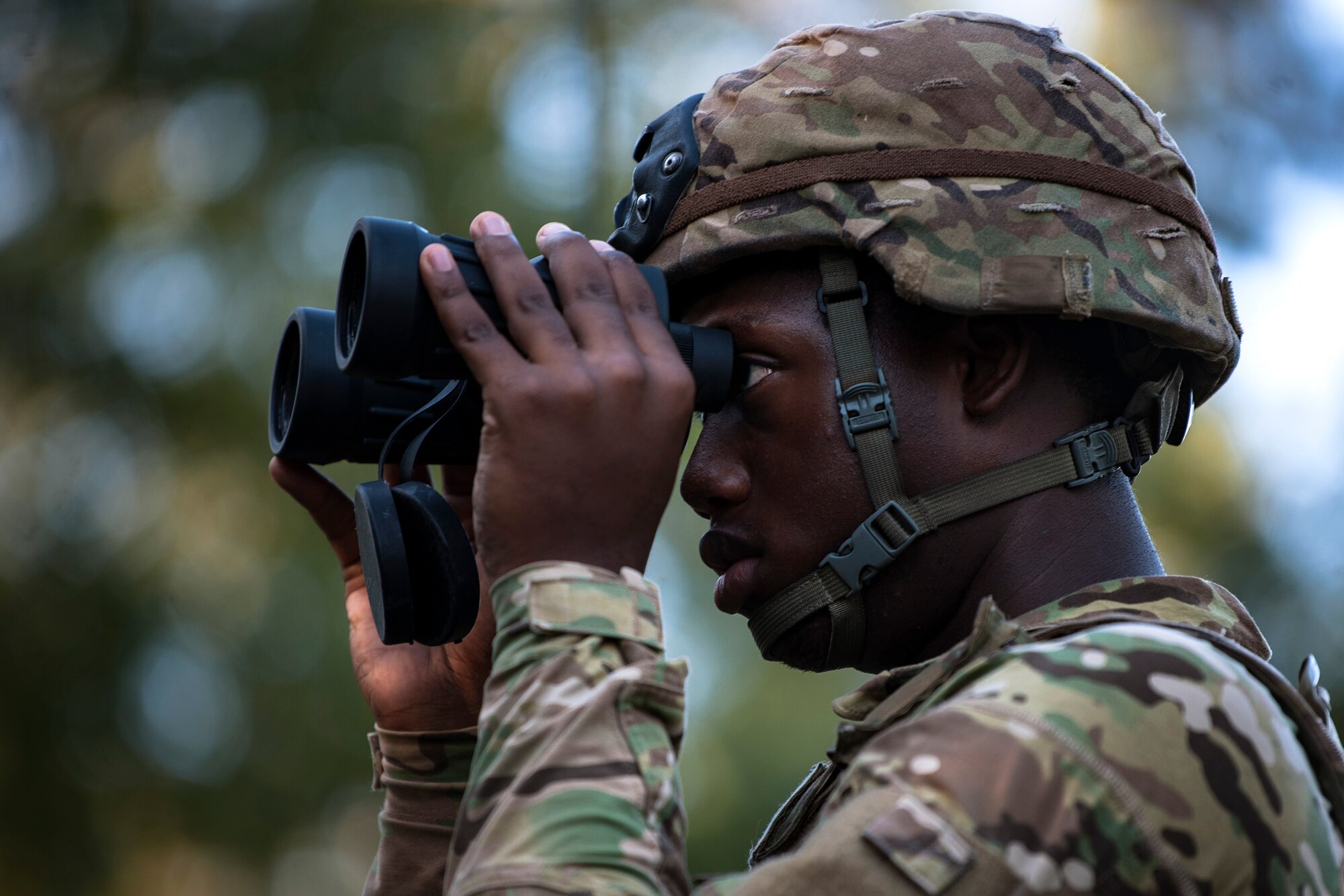 An Airman from the 822d Base Defense Squadron (BDS) scans the woods through his binoculars during a full mission profile assessment, July 24, 2018, at Moody Air Force Base, Ga. The ‘Safeside’ defenders evaluated their base defense tactics and procedures while performing patrols, tactical combat casualty care and countering improvised explosive devices for a mission readiness exercise. After successfully completing these events, the defenders are eligible to earn their Global Response Force status, which certifies the unit to deploy worldwide. (U.S. Air Force photo by Airman Taryn Butler)