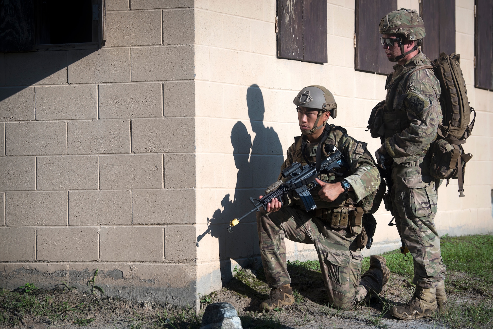 Capt. Lance Wu, left, 822d Base Defense Squadron charlie flight commander, and Staff Sgt. Joseph Lavenski, 822d BDS fire team leader, look around a corner, July 25, 2018, at Moody Air Force Base, Ga. The ‘Safeside’ defenders evaluated their base defense tactics and procedures while performing patrols, tactical combat casualty care and countering improvised explosive devices for a mission readiness exercise. After successfully completing these events, the defenders are eligible to earn their Global Response Force status, which certifies the unit to deploy worldwide. (U.S. Air Force photo by Airman 1st Class Eugene Oliver)