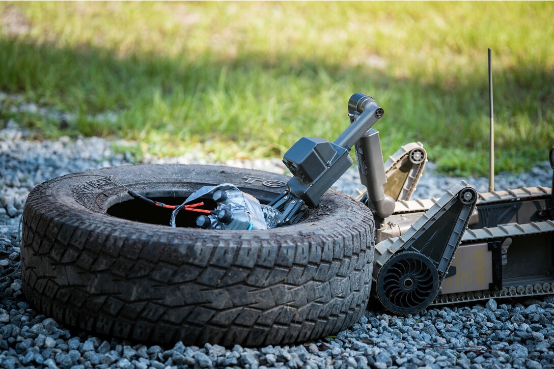 A small unmanned ground vehicle grabs a simulated improvised explosive device, July 25, 2018, at Moody Air Force Base, Ga. The ‘Safeside’ defenders evaluated their base defense tactics and procedures while performing patrols, tactical combat casualty care and countering improvised explosive devices for a mission readiness exercise. After successfully completing these events, the defenders are eligible to earn their Global Response Force status, which certifies the unit to deploy worldwide. (U.S. Air Force photo by Airman 1st Class Eugene Oliver)
