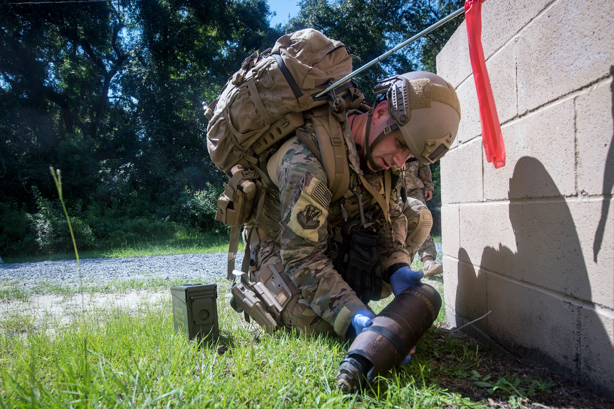 Tech. Sgt. Graham Speight, 822d Base Defense Squadron Explosive Ordnance Disposal team leader, inspects a simulated improvised explosive device, July 25, 2018, at Moody Air Force Base, Ga. The ‘Safeside’ defenders evaluated their base defense tactics and procedures while performing patrols, tactical combat casualty care and countering improvised explosive devices for a mission readiness exercise. After successfully completing these events, the defenders are eligible to earn their Global Response Force status, which certifies the unit to deploy worldwide. (U.S. Air Force photo by Airman 1st Class Eugene Oliver)