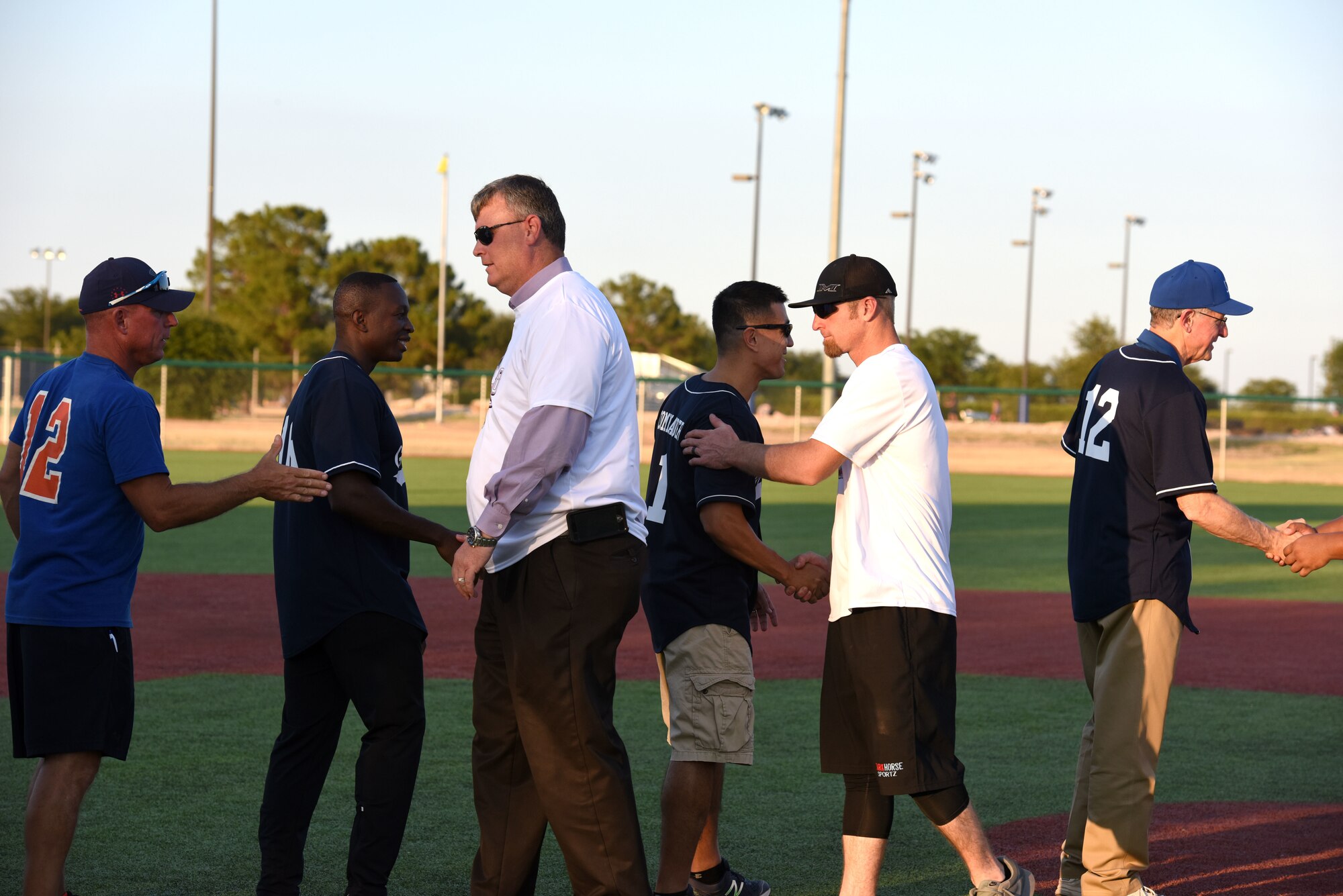 Goodfellow and San Angelo team members congratulate each other at the end of the Stars and Strikes softball game at the Matthis Fitness Center softball field on Goodfellow Air Force Base, Texas, July 31, 2018. The San Angelo All-Star team won the trophy with the final score being 23-6. (U.S. Air Force photo by Airman 1st Class Seraiah Hines/Released)
