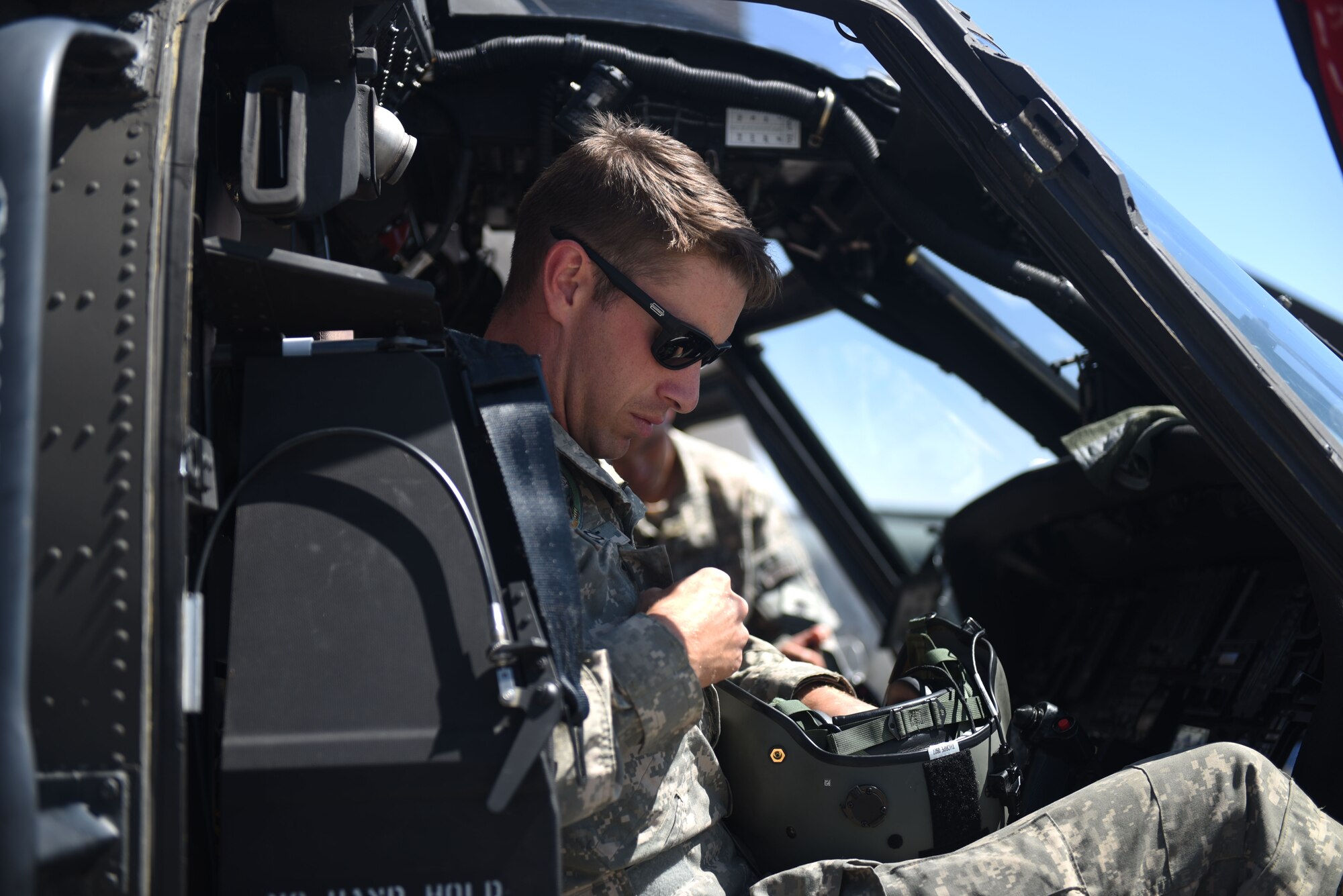 U.S. Army CWC Tim Thrope, 96th Aviation Troop Command co-pilot assigned to JBLM, stows his aviation helmet at Fairchild Air Force Base, Washington, Aug. 1, 2018. Two Washington National Guard Blackhawks were staged at Fairchild to fight the wildfire dubbed “The Sheep Creek Fire.” Washington National Guard efforts are currently focused on keeping the fire south of Sheep Creek, located north of Colville National Forest near the United States-Canadian border. Five 20-member local fire-fighting hand crews are already deployed fighting the fire, very soon to be aided by the WNG and its citizen soldiers. (U.S. Air Force photo/Airman 1st Class Whitney Laine)