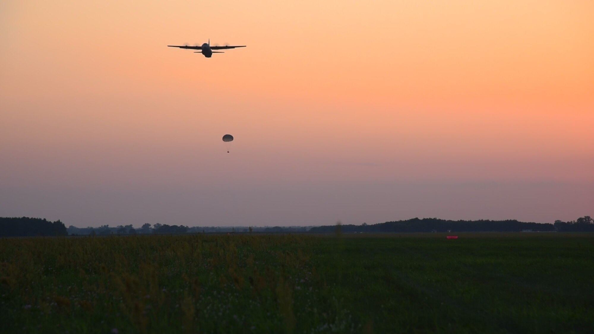 A U.S. Air Force C-130J Super Hercules assigned to the 37th Airlift Squadron drops a supply bundle onto a field at Powidz Air Base, Poland, July 31, 2018, during Aviation Detachment Rotation 18-4. The exercise is a bilateral training event between the U.S. and Polish armed forces that involves tactical airlift scenarios. (U.S. Air Force photo by Senior Airman Kirsten Brandes)