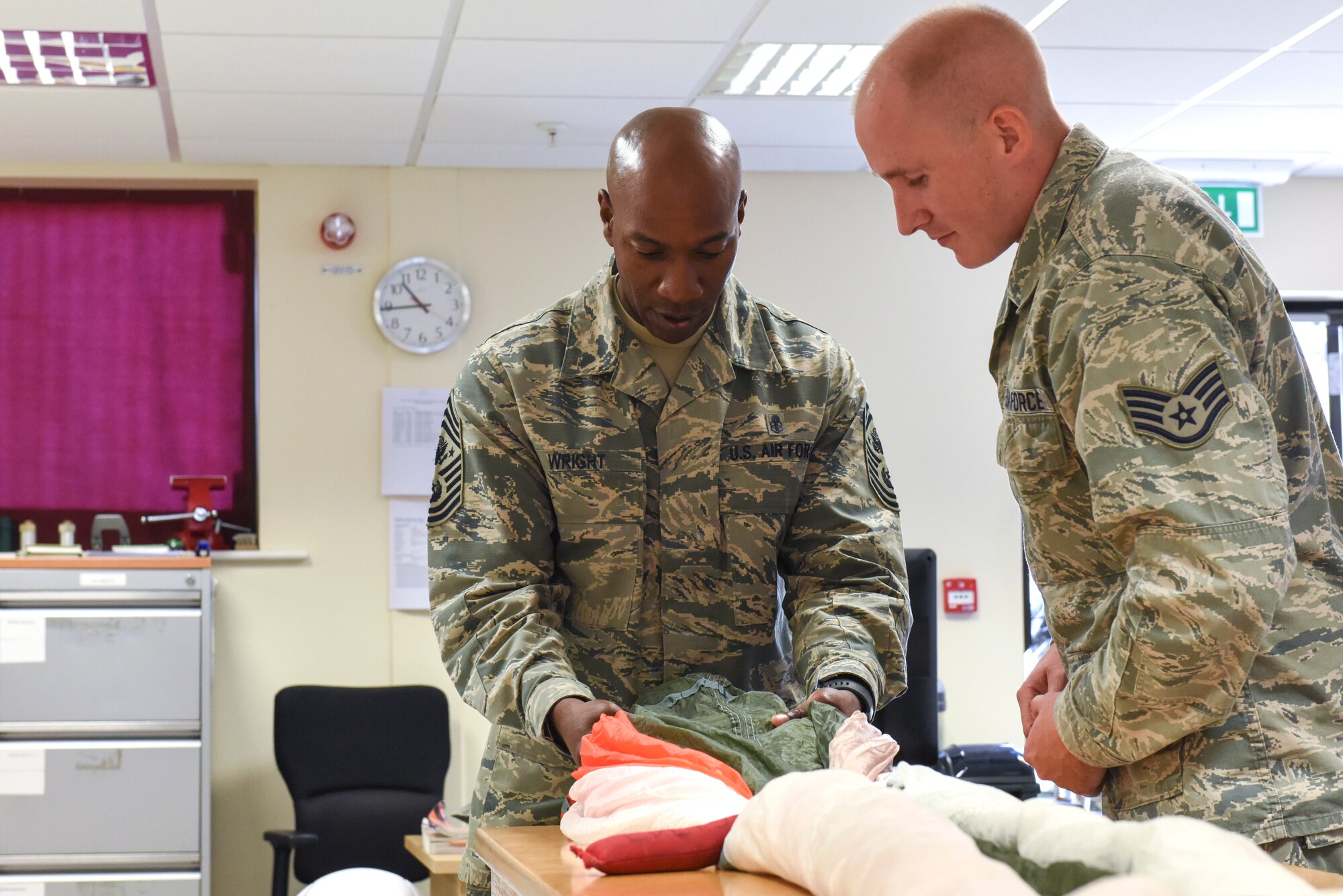 Chief Master Sgt. of the Air Force Kaleth O. Wright learns how to properly fold a parachute at the 48th Operations Group during an immersion tour, Aug. 1, 2018 at Royal Air Force Lakenheath, England. During his visit, Wright met with 48th Fighter Wing Airmen to answer questions and see how they take care of the mission.  (U.S. Air Force photo/Airman 1st Class Christopher S. Sparks)