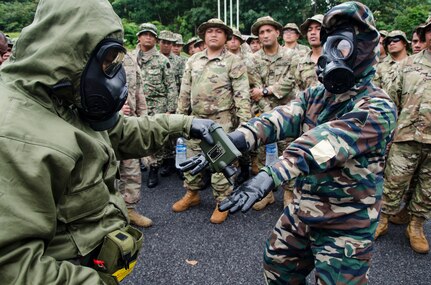 Soldiers with the 15th Royal Malay Regiment scan one another for contamination during Exercise Keris Strike, July 24, 2018, Camp Senawang, Malaysia. Malaysian and U.S. soldiers were working together to teach and train on basic decontamination procedures.