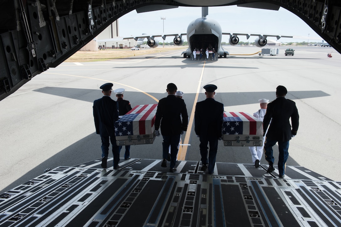 Honor guardsmen, assigned to the Indo-Pacific Command, move flag-draped cases from a U.S. Air Force C-17 Globemaster III aircraft during an honorable carry ceremony at Joint Base Pearl Harbor-Hickam, Hawaii, Aug. 1, 2018.