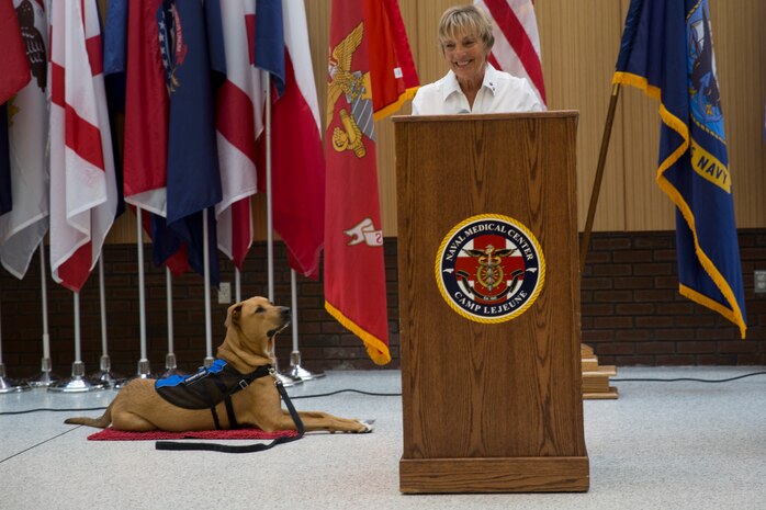 Sunnie Tortorici, a therapy dog trainer, explains the important role her trainee, Pappy Boyington, will play at the Naval Medical Center Camp Lejeune, N.C., July 10, 2018. According to the NMCCL, Pappy is part of the Canine Visitation Program which seeks to facilitate patient recovery, decrease stress levels, and provide a communication medium for patients, family and personnel. (U.S. Marine Corps photo by Lance Cpl. Nathan Reyes)