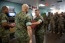 Col. Thomas Bruno, chief of staff, Marine Corps Installations East, Marine Corps Base Camp Lejeune, presents Cpl. Edward Hossler, food service specialist, 2d Marine Logistics Group, with a training certificate at Mess Hall 128, Marine Corps Base Camp Lejeune, July 11. The training teaches Marine food service specialists methods to improve the basic services they provide involving baking, roasting, recipe use, cold food preparation and grilling. (U.S. Marine Corps photo by Lance Cpl. Ashley Gomez)