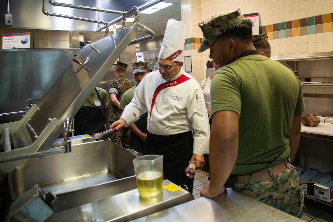 Stephen Dziedzic, executive chef, Sodexo, instructs Marines in cold food preparation at Mess Hall 128, Camp Lejeune, N.C., July 11, 2018. The training teaches methods to Marine food service specialists to improve the basic services involving baking, roasting, recipe use, cold food preparation and grilling. (U.S. Marine Corps photo by Lance Cpl. Ashley Gomez)