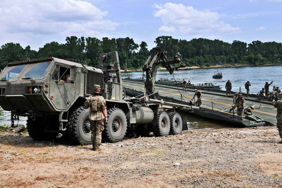 Soldiers prepare to position a portion of a temporary floating bridge.