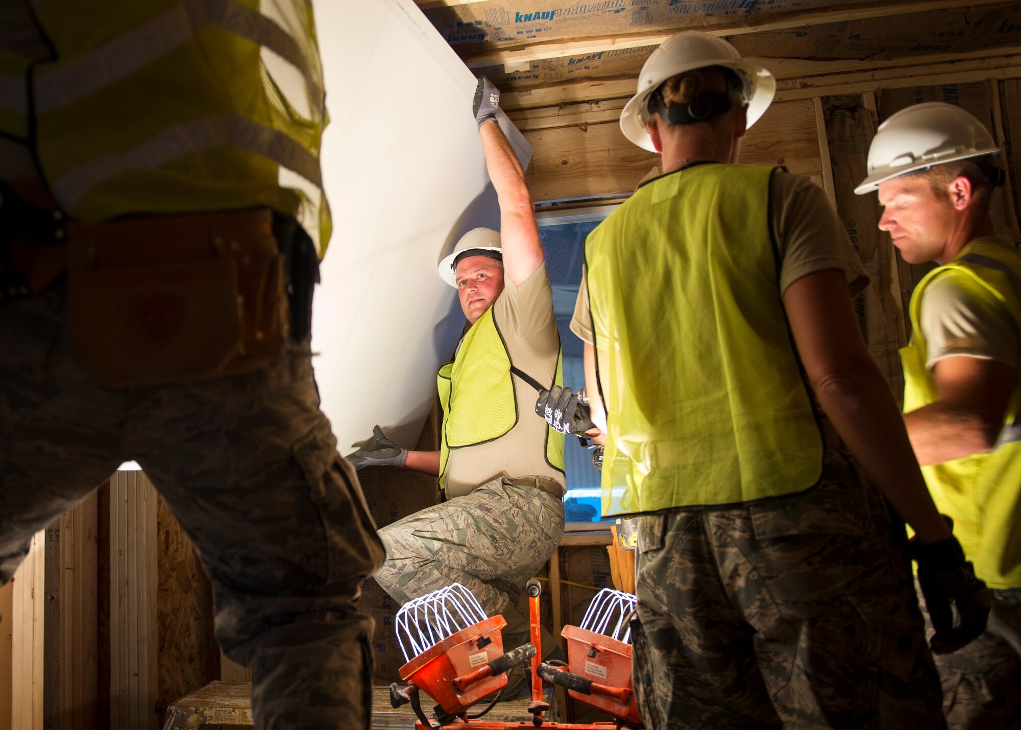 U.S. Air Force Staff Sgt. Donald Johnson, an electrician from the 133rd Civil Engineer Squadron, helps hang a sheet of drywall within a transportable modular home in Gallup, N.M., July 23, 2018.