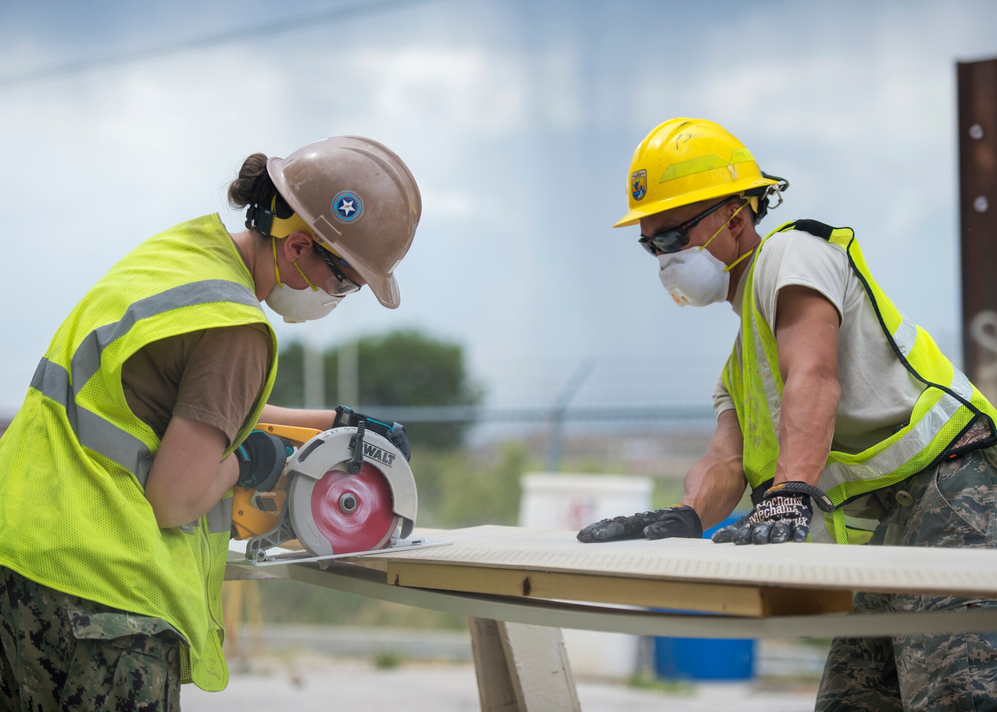 U.S. Air Force Staff Sgt. Mark Spitznogle (right), from the 133rd Civil Engineer Squadron Structures shop, holds down a piece of fascia while a U.S. Navy Seabee (left) makes a cut in Gallup, N.M., July 23, 2018.