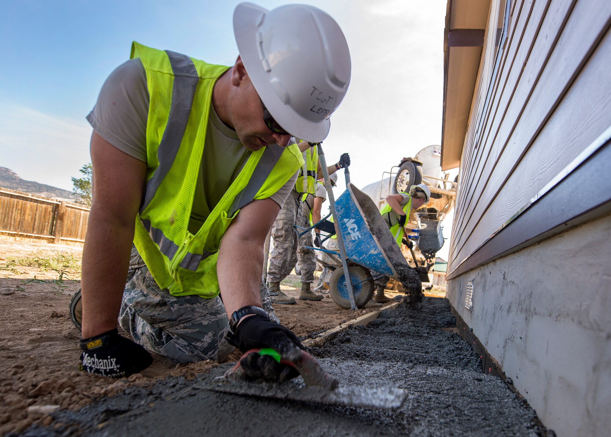 U.S. Air Force Tech. Sgt. Scott Leffler, 133rd Civil Engineer Squadron Structures shop, smooths out a recently poured apron around a recently constructed modular home in Gallup, N.M., July 25, 2018.