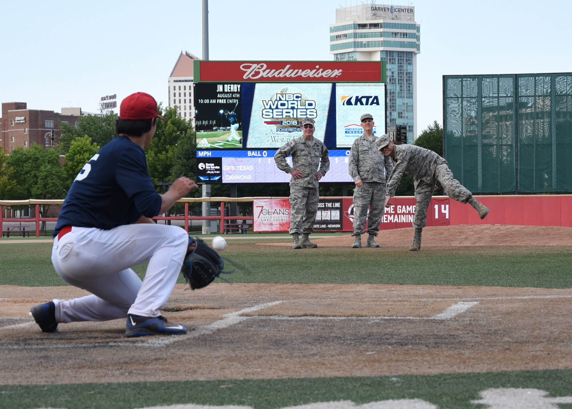 Airman 1st Class Anthony Binas throws the first pitch at a National Baseball Congress World Series baseball game.