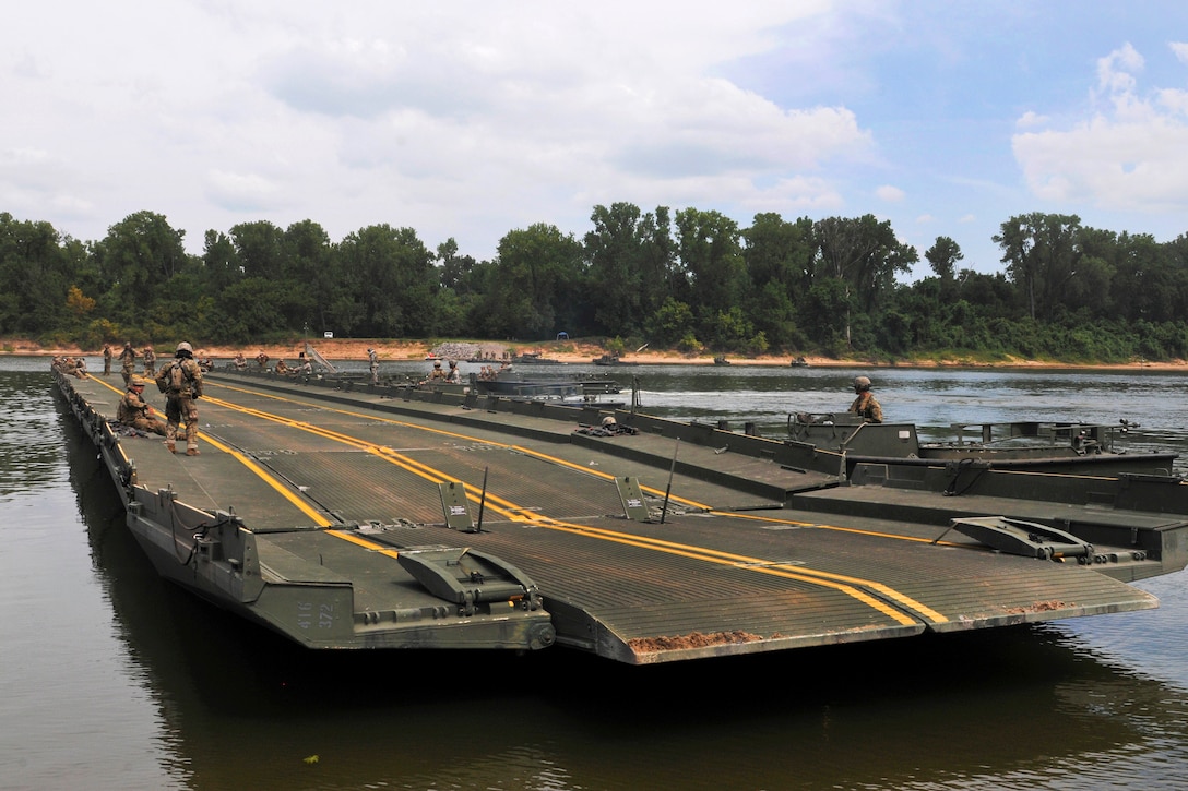 Soldiers prepare to position a temporary floating bridge.