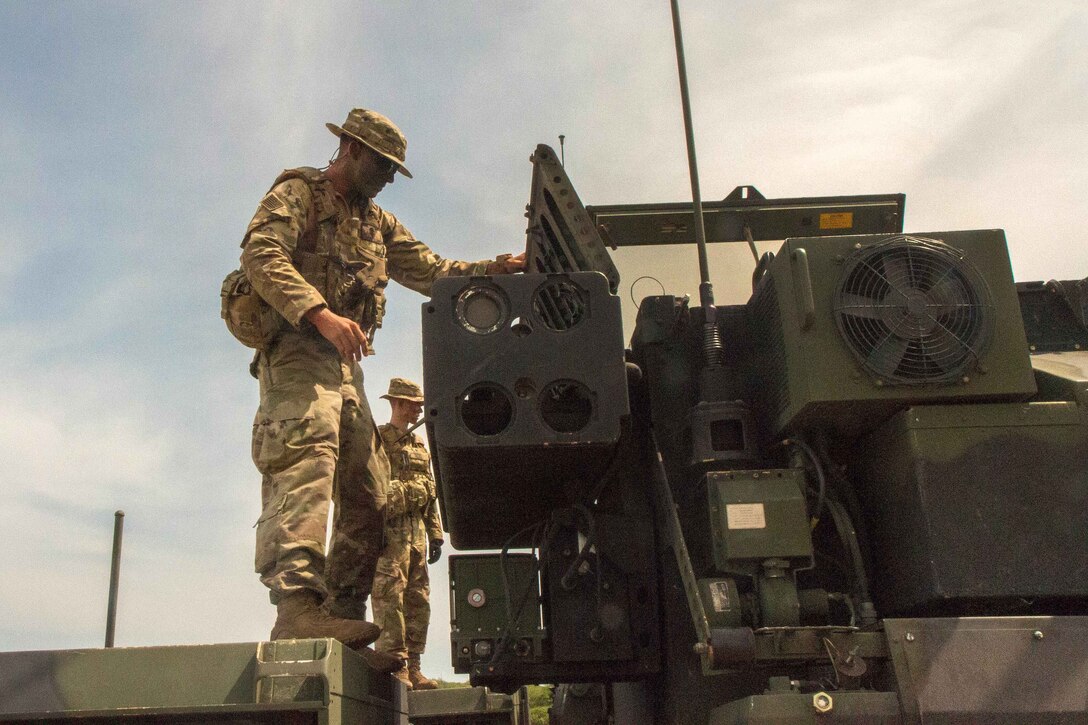 A soldier prepares to load a stinger missile onto an Avenger air defense system.