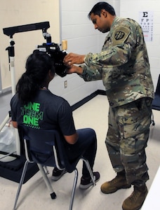 Maj. Riz Khan, an optometrist, completes an eye exam for a local resident receiving medical services at Betty Harwell Middle School in Edinburg, Texas. Approximately 50 U.S. Army Reserve Soldiers assigned to the 7235th Medical Support Unit out of Orlando, Texas, worked in partnership with the Texas A&M Colonias program June 16-27 to provide medical care to Hidalgo County's underserved colonia population. Services provided by military personnel are done through the Department of Defense's Innovative Readiness Training, a civil-military program that builds mutually beneficial partnerships between U.S. communities and the DOD. The missions selected meet training & readiness requirements for Army Reserve service members while integrating them as a joint and whole-of-society team to serve our American citizens.