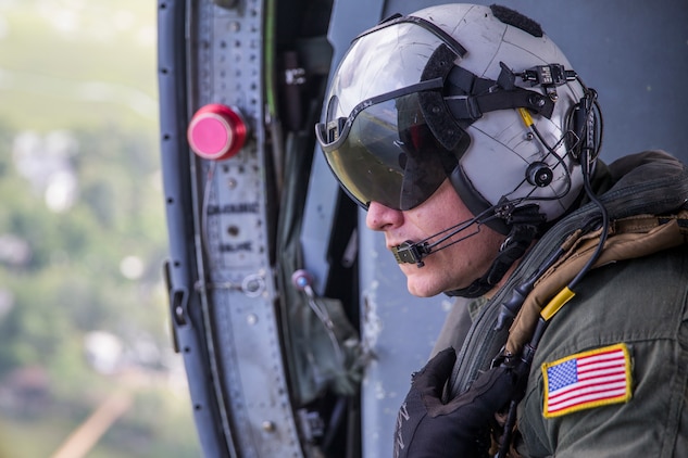 U.S. Navy AWS1 Joseph Southern flies aboard a MH-60S Knighthawk helicopter during a Search and Rescue (SAR) training exercise in Beaufort S.C., July 27, 2018.  The purpose of the exercise was to practice and hone professional skills to aid to people in immediate danger or distress. The exercise was a full community involvement including participants from the U.S. military, Naval Hospital Beaufort, and first responders within Beaufort County. (U.S. Marine Corps photo by Cpl. Erin R. Ramsay / Released)