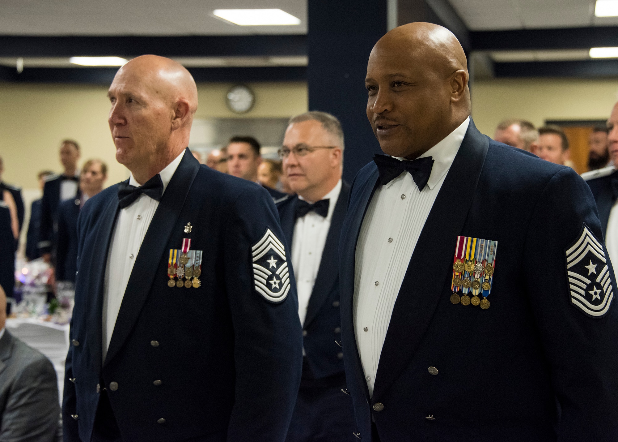 188th Wing Command Chief Master Sergeant Steven R. Bradley (left) and 189th Airlift Wing Command Chief Master Sergeant Ronald O. Boston proudly sign the Air Force Song during the 188th Wing's inaugural Senior Non-commissioned Officer Induction Ceremony, held at Ebbing Air National Guard Base, Ark., June 2, 2018. The wing celebrated the accomplishments of its newest senior NCOs during the evening's event. (U.S. Air National Guard photo by Tech. Sgt. John E. Hillier)
