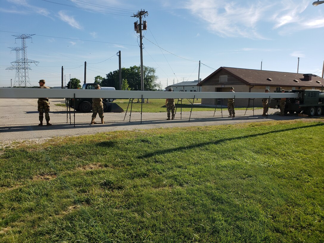 U.S. Army Reserve Soldiers from the 317th Engineer Company, out of Homewood, Ill., assemble an Automated Building Machine to assist in the construction a 4,000 square foot Quonset hut at Joliet Training Area, in Elwood, Ill., as part of a Troop Support Project during their Annual Training, July 19.