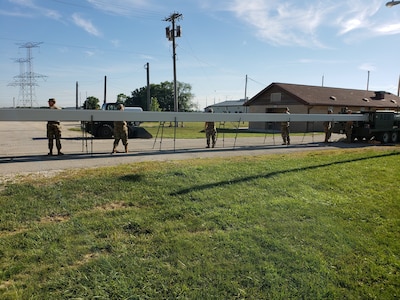 U.S. Army Reserve Soldiers from the 317th Engineer Company, out of Homewood, Ill., assemble an Automated Building Machine to assist in the construction a 4,000 square foot Quonset hut at Joliet Training Area, in Elwood, Ill., as part of a Troop Support Project during their Annual Training, July 19.