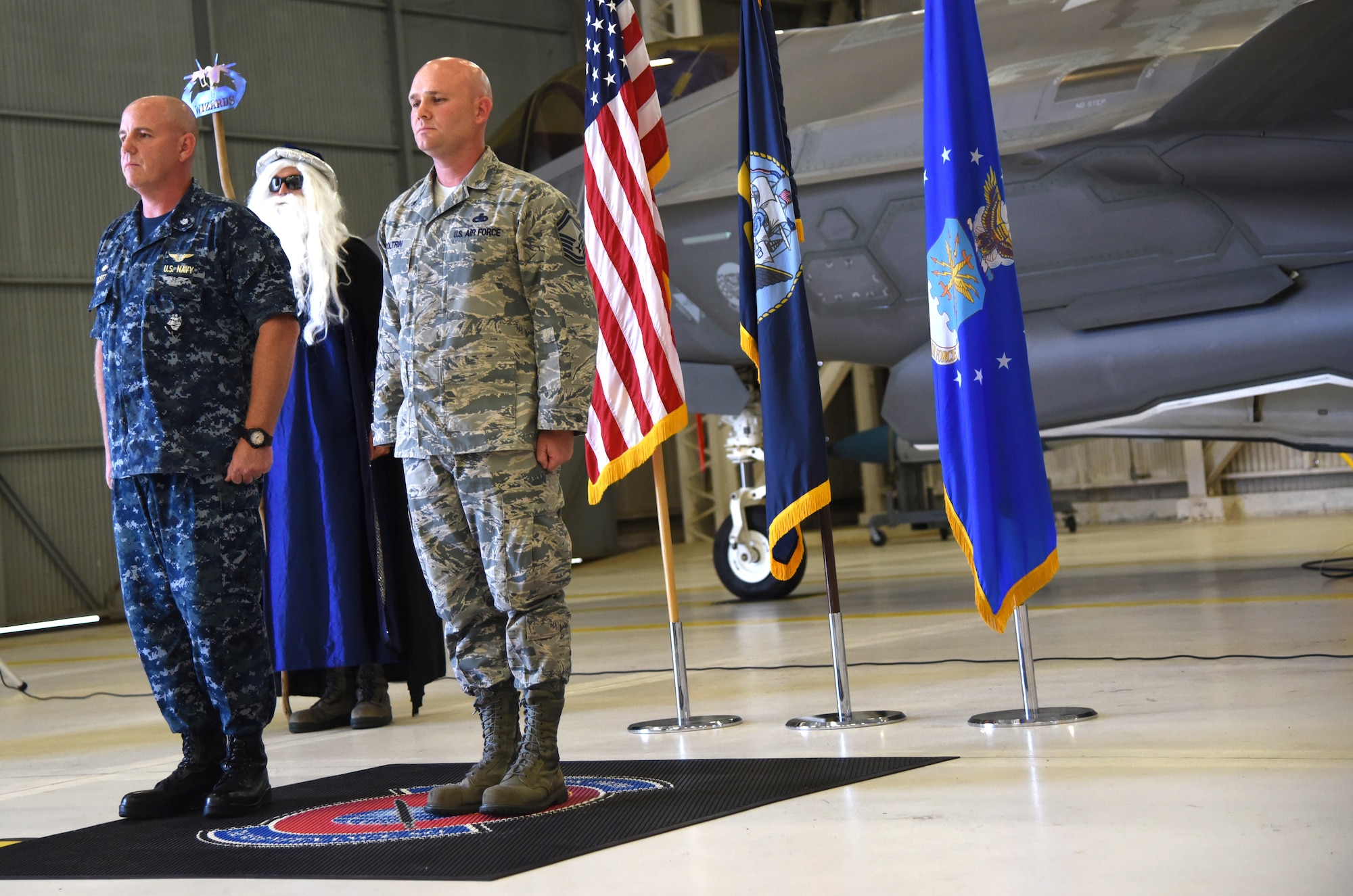 U.S. Navy Cmdr. Matthew Scott and Chief Master Sgt.(select) Matthew Coltrin stand at attention while the promotion orders are read during the first enlisted frocking ceremony in Air Education and Training Command on Aug. 1, 2018 at Eglin AFB, Fla. A frocking ceremony allows a military member to pin on new rank prior to their promotion date. (U.S. Air Force photo by 1st Lt. Savannah Stephens)