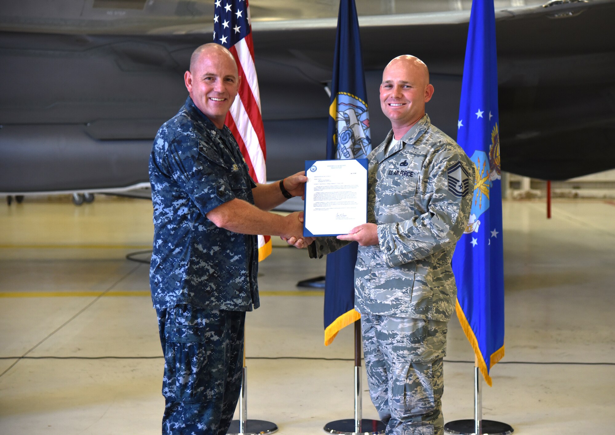U.S. Navy Cmdr. Matthew Scott and Chief Master Sgt.(select) Matthew Coltrin, pose for a photo during the first enlisted frocking ceremony in Air Education and Training Command on Aug. 1, 2018 at Eglin AFB, Fla. A frocking ceremony allows a military member to pin on new rank prior to their promotion date. (U.S. Air Force photo by 1st Lt. Savannah Stephens)