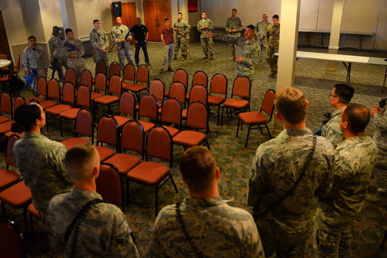 Senior Master Sgt. Christopher Enfinger (center right), 47th Security Forces Squadron security forces manager, briefs defenders and firefighters during a training scenario at Laughlin Air Force Base, Texas, Aug. 1, 2018. With more than 20 years of civilian law enforcement, and more than eight years of special weapons and tactics, or SWAT, experience, Enfinger passed on his knowledge to Laughlin’s defenders as they move to a new way to handle active shooter scenarios. (U.S. Air Force photo by Senior Airman Benjamin N. Valmoja)