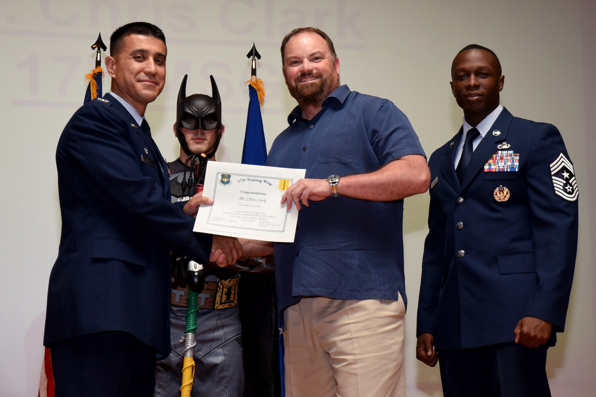U.S. Air Force Col. Ricky Mills, 17th Training Wing commander, presents the Civilian Non-supervisory Category II of the Quarter certificate to Chris Chuck, with Chief Master Sgt. Lavor Kirkpatrick, 17th TRW command chief, during the 17th TRW quarterly awards ceremony at the Base Theater on Goodfellow Air Force Base, Texas, July 31, 2018. (U.S. Air Force photo by Airman 1st Class Seraiah Hines/Released)