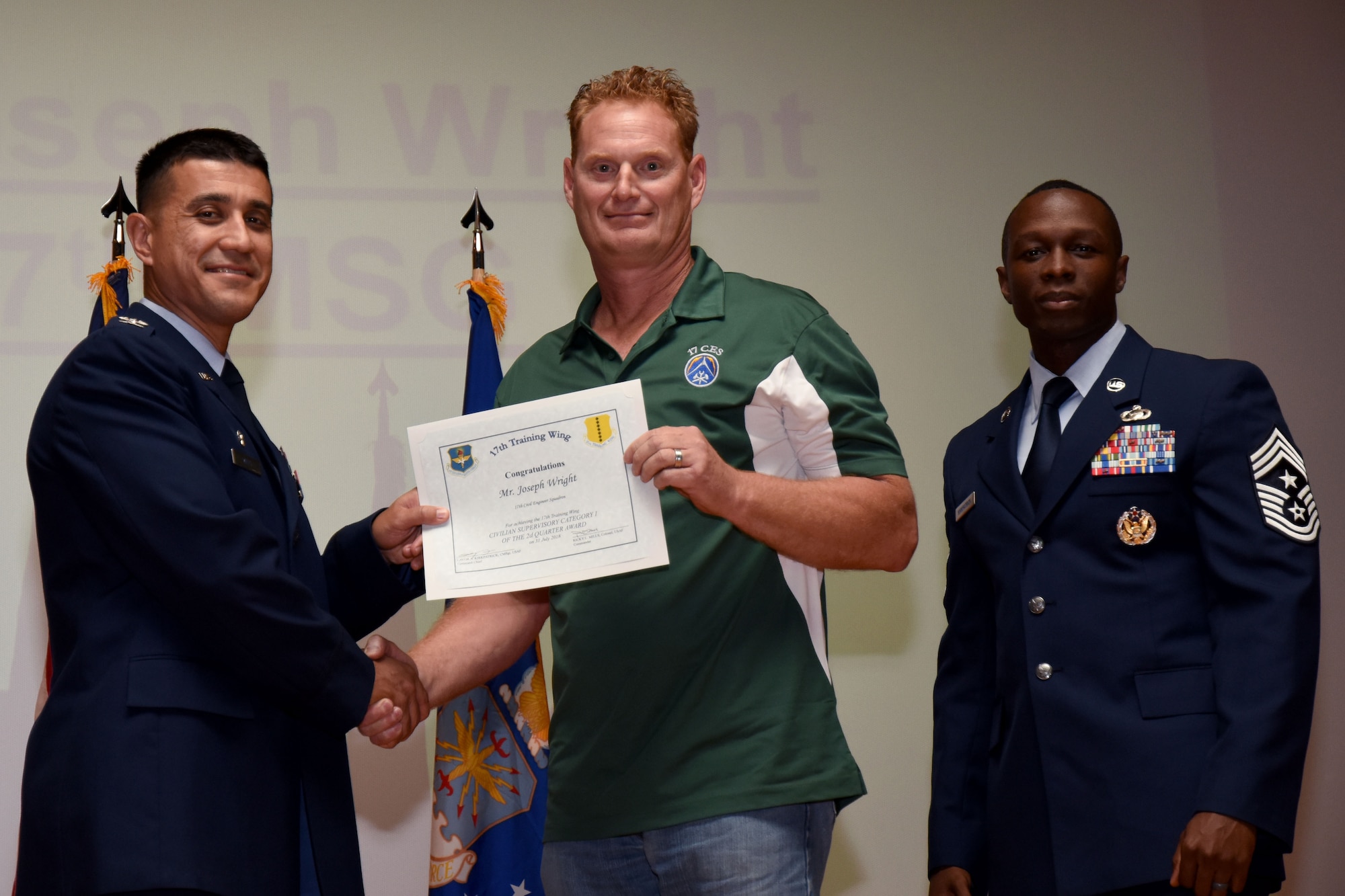 U.S. Air Force Col. Ricky Mills, 17th Training Wing commander, presents the Civilian Supervisory Category I of the Quarter certificate to Joseph Wright, with Chief Master Sgt. Lavor Kirkpatrick, 17th TRW command chief, during the 17th TRW quarterly awards ceremony at the Base Theater on Goodfellow Air Force Base, Texas, July 31, 2018. (U.S. Air Force photo by Airman 1st Class Seraiah Hines/Released)
