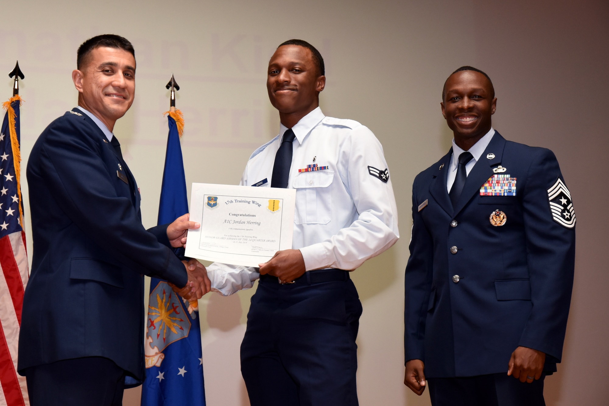 U.S. Air Force Col. Ricky Mills, 17th Training Wing commander, presents the Civilian Supervisory Category I of the Quarter certificate to Joseph Wright, with Chief Master Sgt. Lavor Kirkpatrick, 17th TRW command chief, during the 17th TRW quarterly awards ceremony at the Base Theater on Goodfellow Air Force Base, Texas, July 31, 2018. (U.S. Air Force photo by Airman 1st Class Seraiah Hines/Released)