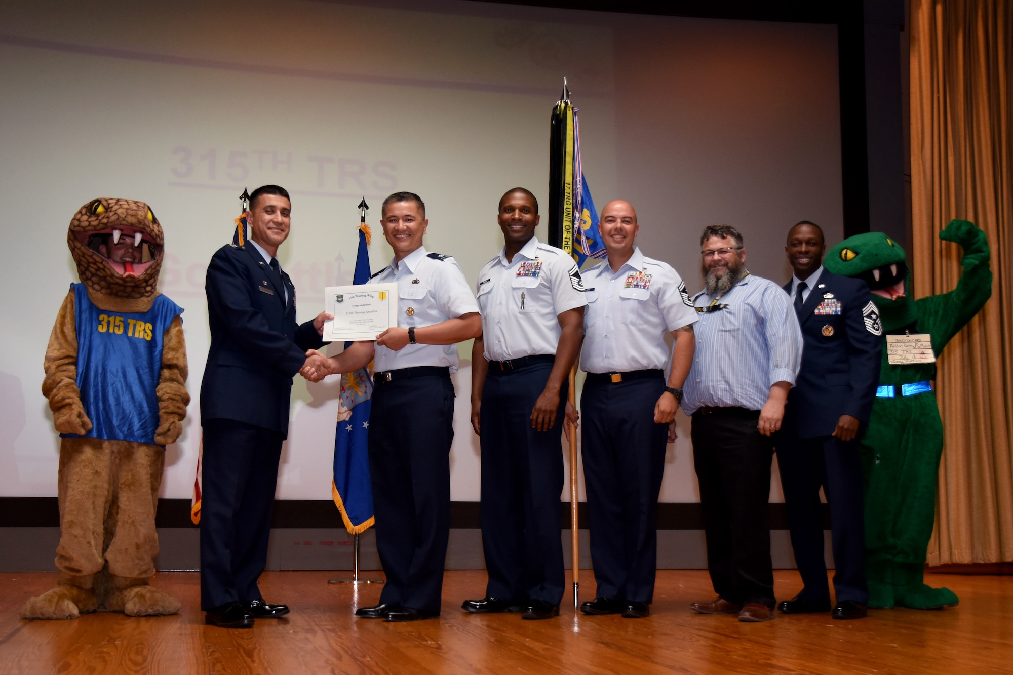 U.S. Air Force Col. Ricky Mills, 17th Training Wing commander, presents the Unit of the Quarter certificate to Lt. Col. Mark Chang, 315th Training Squadron commander, with Chief Master Sgt. Lavor Kirkpatrick, 17th TRW command chief, during the 17th TRW quarterly awards ceremony at the Base Theater on Goodfellow Air Force Base, Texas, July 31, 2018. (U.S. Air Force photo by Airman 1st Class Seraiah Hines/Released)