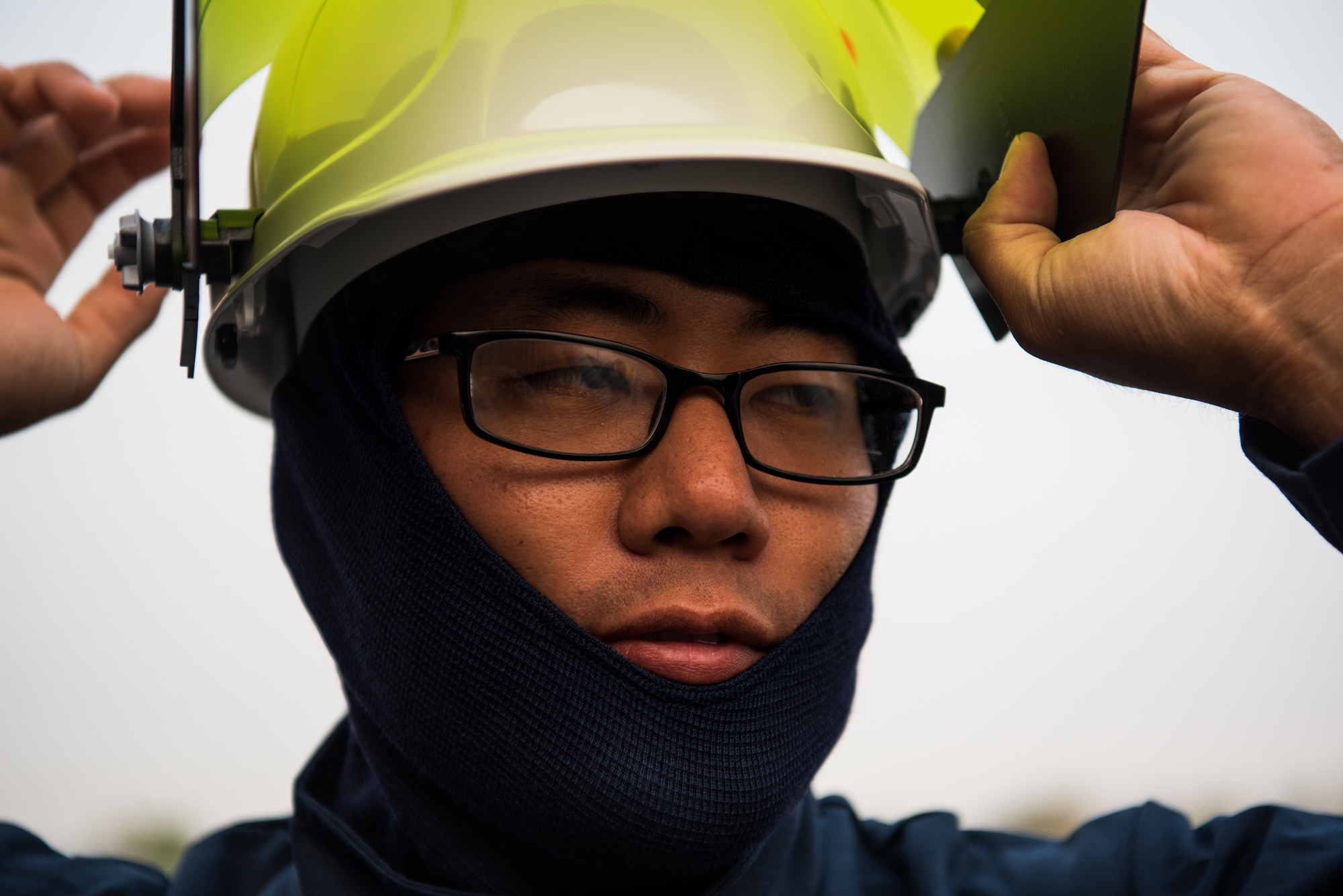 Airman 1st Class Charles Song, 9th Civil Engineer Squadron heating, ventilation and air conditioning technician, secures his personal protective equipment before working with high voltage equipment at  Beale Air Force Base, California, Aug. 2, 2018. Arch flash gear is rated to protect the wearer if there is an electric explosion. (U.S. photo by Senior Airman Justin Parsons)