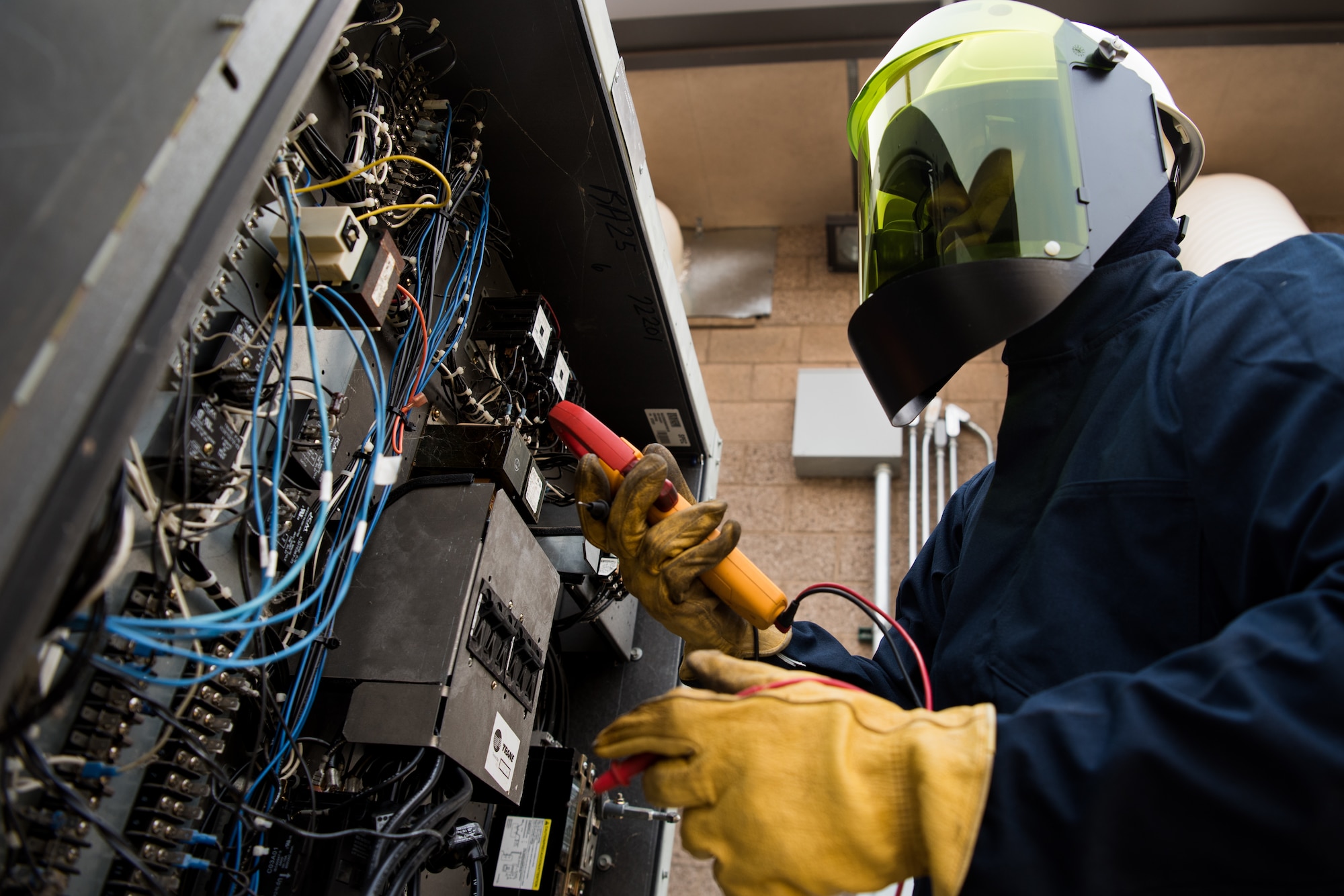 Airman 1st Class Charles Song, 9th Civil Engineer Squadron heating, ventilation and air conditioning technician, inspects electrical connections to determine the cause of systems malfunction at Beale Air Force Base, California, Aug. 2, 2018. HVAC Airmen are required to wear personal protective equipment when working on systems that have hazards such as refrigeration high pressure and units with up to 480 voltages. (U.S. photo by Senior Airman Justin Parsons)