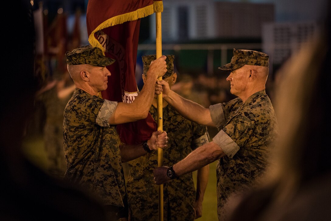 Lt. Gen. Lawrence D. Nicholson (right) hands Lt. Gen. Eric M. Smith (left) the command colors during a III Marine Expeditionary Force change of command ceremony, Aug. 2, 2018, at the parade deck aboard Camp Courtney, Okinawa, Japan. Nicholson relinquished his duties as the commanding general of III MEF to Smith. Smith arrived from 1st Marine Division where he served as the commanding general. (U.S. Marine Corps photo by Sgt. Matthew J. Bragg)