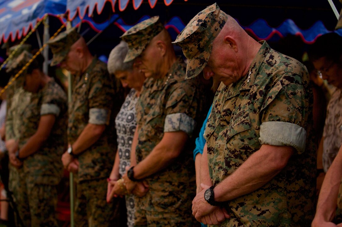 Service members, families, and distinguished guests bow their heads in prayer during the III Marine Expeditionary Force change of command ceremony Aug 2, 2018, at Camp Courtney, Okinawa, Japan. During the ceremony, Lt. Gen. Lawrence D. Nicholson relinquished command of III MEF to Lt. Gen. Eric M. Smith. (U.S. Marine Corps photo by Lance Cpl. Harrison Rakhshani)