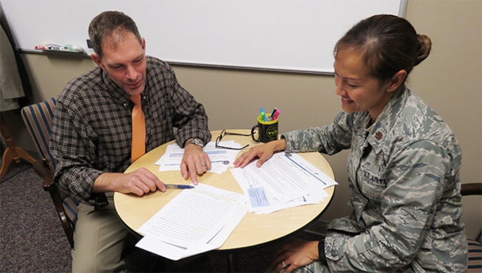 Male civilian staff member tutoring a female military officer