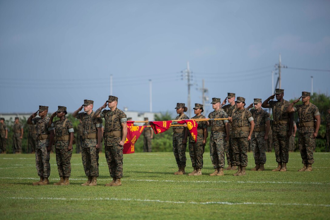 Platoon commanders and platoon sergeants stand with the company colors of Headquarters Regiment, 3rd Marine Logistics Group, during a relief and appointment ceremony for Headquarters Regiment, 3rd Marine Logistics Group, Aug. 3, 2018 at Camp Kinser, Okinawa, Japan. Sgt. Maj. James E. Monroe ceremoniously transferred accountability and authority of enlisted Marines to Hammock during the ceremony. (U.S. Marine Corps photo by Lance Cpl. Jamin M. Powell)