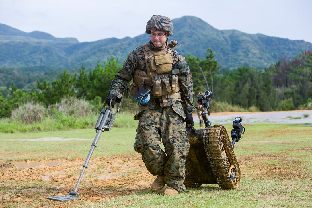 Staff Sgt. David Cain retrieves a Mark II Talon Explosive Ordnance Disposal robot during charge employment training Aug. 2, 2018 at Camp Hansen, Okinawa, Japan. The training taught EOD technicians to effectively neutralize improvised explosive devices  with unmanned robotic platforms by safely finding and removing any hazards. Cain, a native of Fredericksburg, Virginia, is an EOD technician with EOD Company, 9th Engineer Support Battalion, 3rd Marine Logistics Group. (U.S. Marine Corps photo by Lance Cpl. Isabella Ortega)
