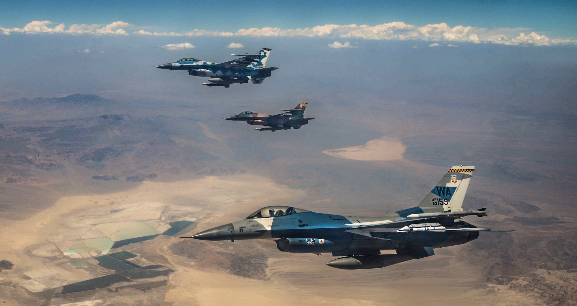 Three F-16 Fighting Falcon fighter jets assigned to the 64th Aggressors Squadron (AGRS) fly over the Nevada Test and Training Range during Red Flag 18-3. The 64th AGRS served as part of the red forces during Red Flag 18-3 to prepare combat air forces, joint and allied aircrews for tomorrow's victories with challenging and realistic scenarios. (U.S. Air Force photo by Airman Bailee A. Darbasie)