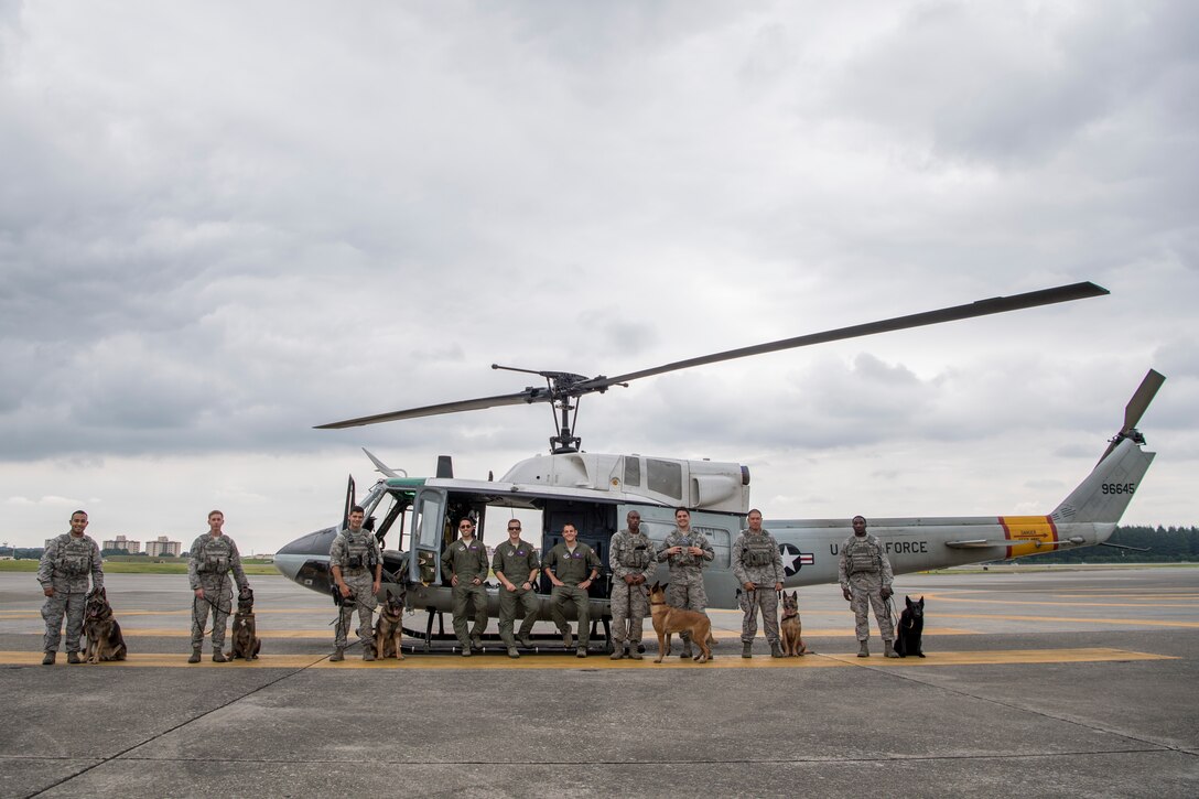 Members of the 374th Security Forces Squadron military working dog section, and the 458th Airlift Squadron UH-1N crew, pose for a photo July 26, 2018, at Yokota Air Base, Japan.