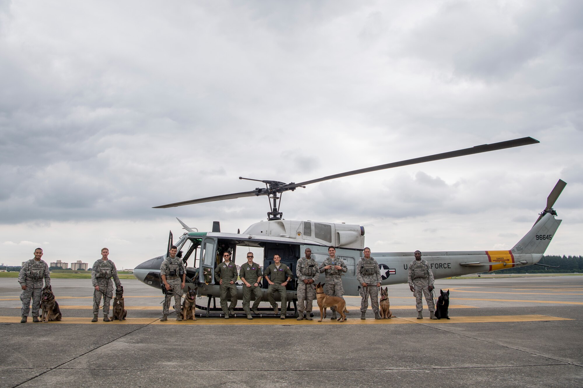Members of the 374th Security Forces Squadron military working dog section, and the 458th Airlift Squadron UH-1N crew, pose for a photo July 26, 2018, at Yokota Air Base, Japan.