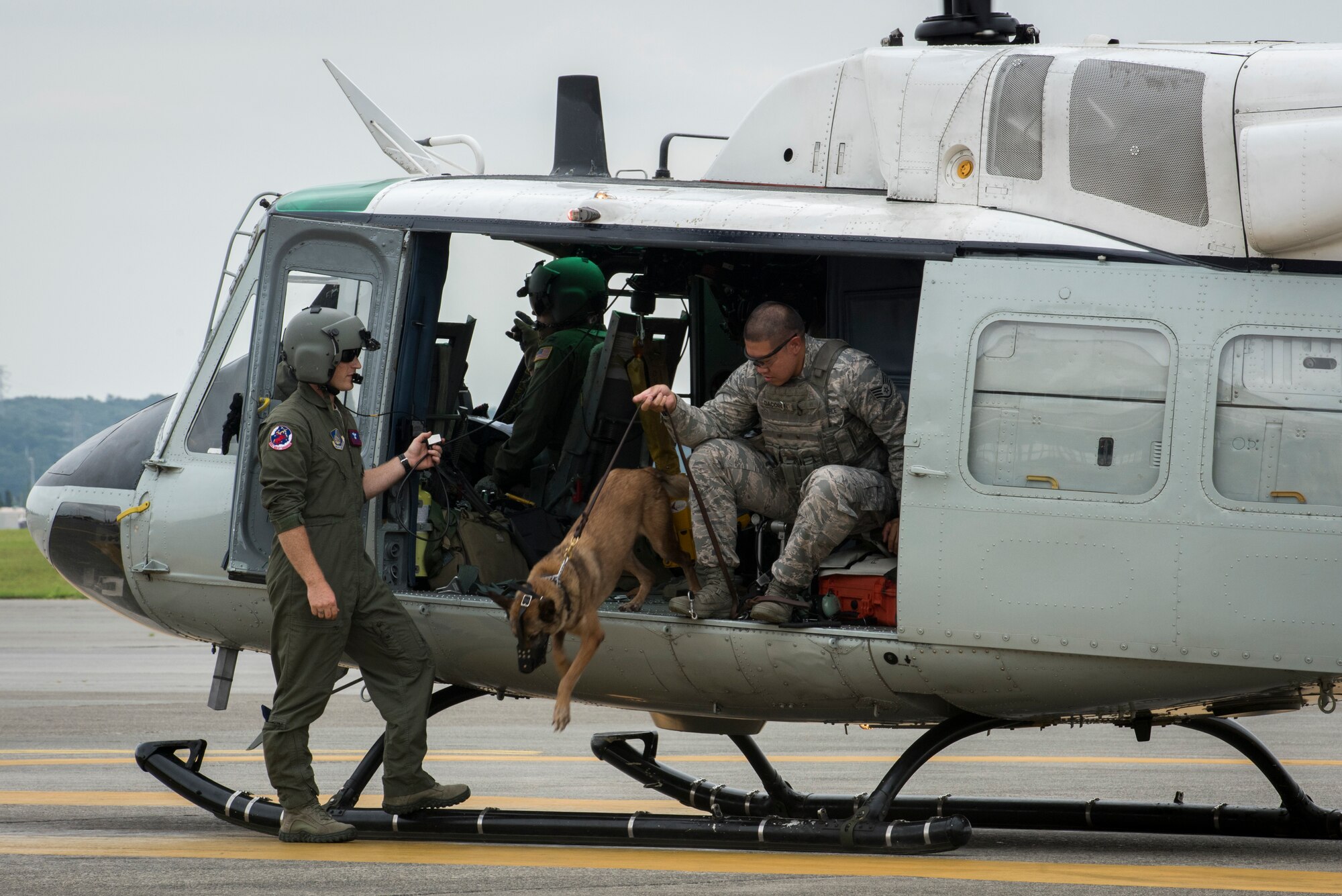 Staff Sgt. Michael Dacoron, 374th Security Forces Squadron military working dog handler, and Diesel, 374 SFS MWD, jump out of a UH-1N helicopter after a 459th Airlift Squadron MWD familiarization flight July 26, 2018, at Yokota Air Base, Japan.