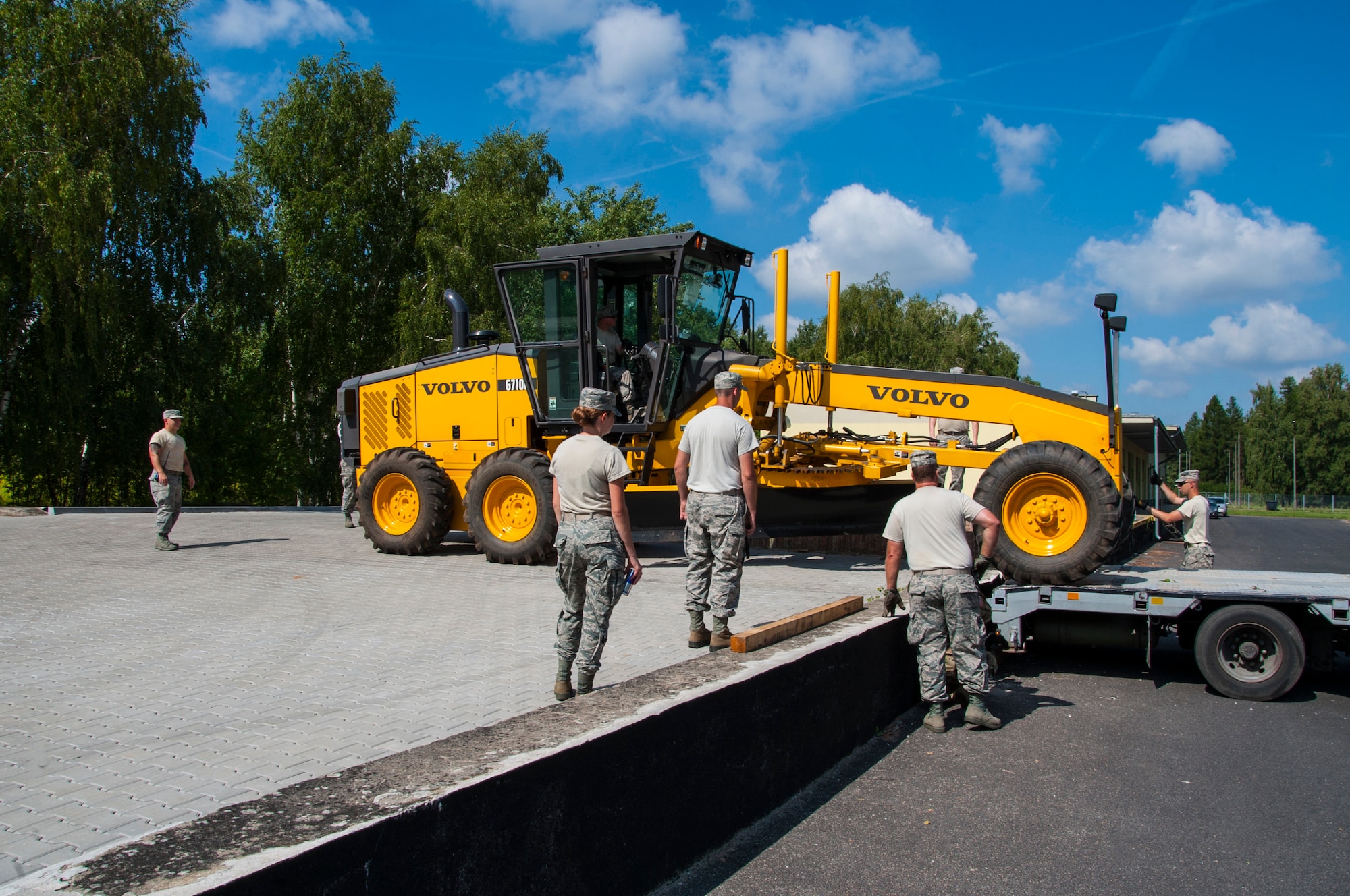 U.S. Air National Guard Airmen guide a Volvo 6710B Grader vehicle onto an off-loading dock during the Deployable Air Base System proof of concept exercise at the 31st Tactical Air Base, Poznan-Krzesiny, Poland, July 30, 2018. The exercise tests and enhances the ability to rapidly deploy within theatre, preposition equipment and enables the execution of current operations, exercises and contingencies. (U.S. Army photo by Spc. Craig Jensen)